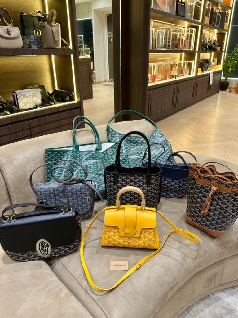 Goyard handbag collection on boutique sofa